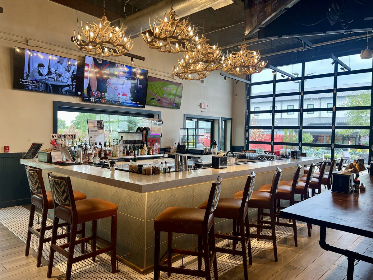 The Mantel’s bar under the antler chandeliers, with games on the TVs