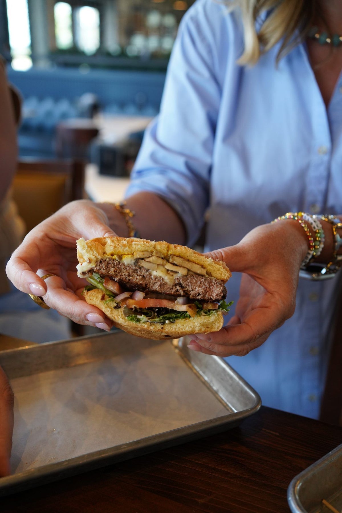 A guest holding a Wagyu burger cut in half