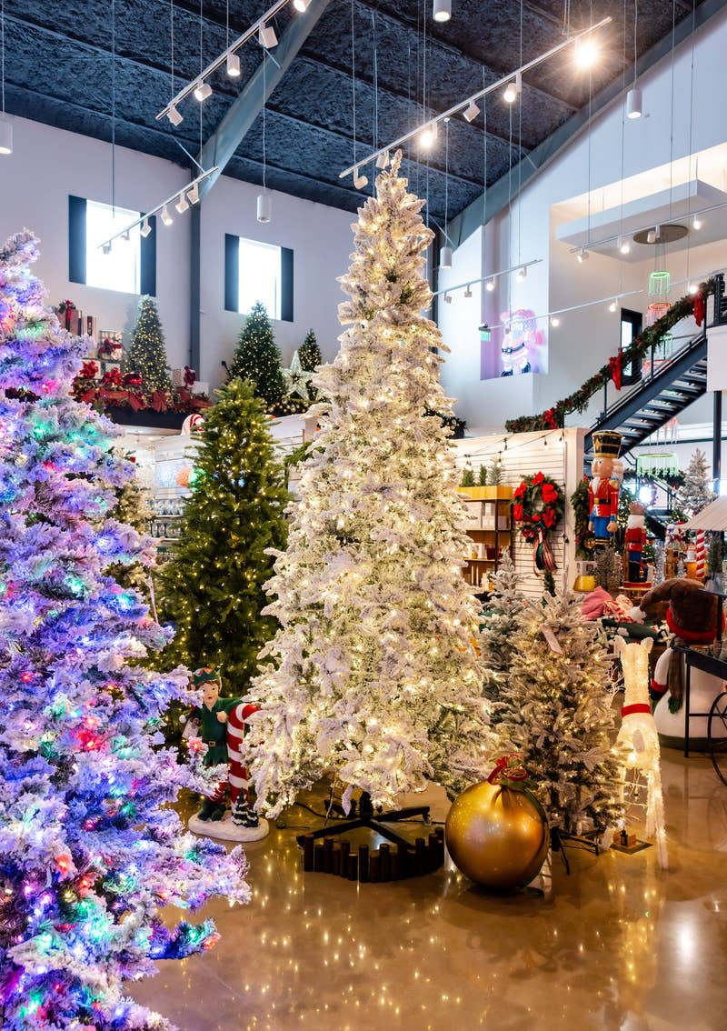 A designer Christmas tree glowing with warm white lights in the Madisonville showroom